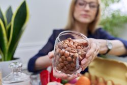 Fındıkla Gelen Güzellik: Saçtan Cilde Doğal Bakım Önerileri Hazel nuts in a glass jar in a woman's hands close-up