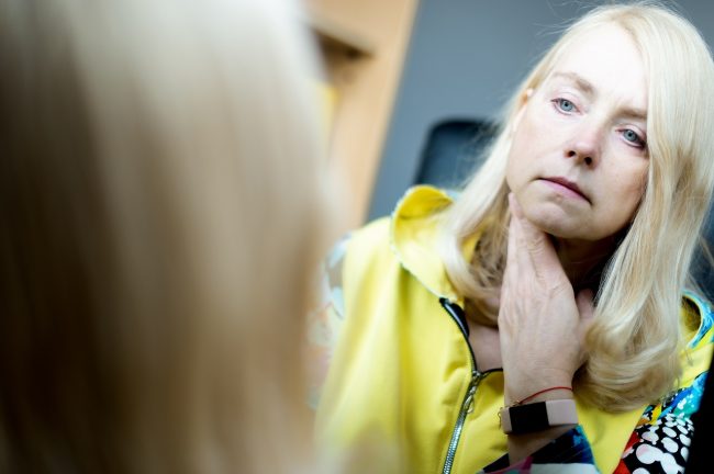 Graves Hastalığı Belirtileri Portrait of middle-aged woman looking at her face in mirror, skin aging concept