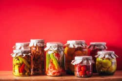 Konservenin Renkli Dünyası: Turşudan Reçele ucumber, squash and tomatoes pickling and canning into glass jars. Ingredients for vegetables preserving. Healthy fermented food concept. Harvest storing