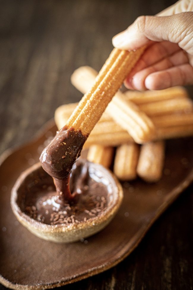 churros youtiao sıcak çikolata tulumba tatlısı Spanish tapas churros with sugar and chocolate sauce. Dark backg