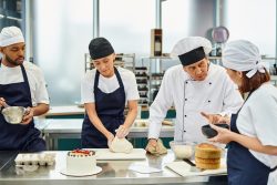 Pastacılık Eğitimi: Tatlı Sanatının Profesyonel Yolculuğu | Kariyer, Kurslar ve Fırsatlar good looking mature chief cook working with his multicultural chefs on kitchen, confectionary